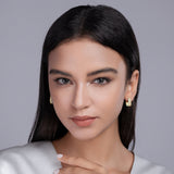 Model wearing triple-row square pavé huggie earrings; yellow gold vermeil with clear stones