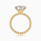 Solitaire round-cut moissanite ring with yellow gold plated beaded shank and raised prongs