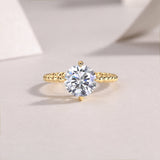 Round moissanite solitaire ring in yellow gold plated with beaded shoulders and prong setting