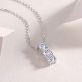 Close-up: three-stone vertical bar moissanite pendant on silver-tone chain