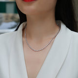 Moissanite tennis necklace worn at collarbone, white gold vermeil with round bezel stones