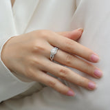 Round halo pavé moissanite engagement ring on hand with center round stone and pavé band