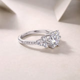 Round moissanite pavé ring with pavé band and clustered side stones, white gold