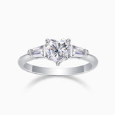 Three-stone moissanite ring with heart-cut center and baguette side stones, white gold tone band