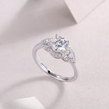 Round moissanite halo engagement ring with side pavé and raised center setting