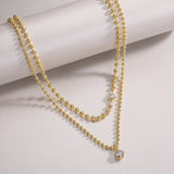 Double-layer beaded necklace set with round blue gem accents on both strands, yellow gold