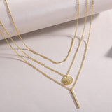 Layered necklace showing coin pendant and bar charm, yellow gold vermeil, three chain layers