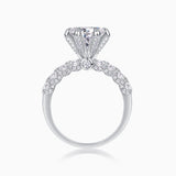 Top view of six-prong pavé moissanite engagement ring, round center stone detail