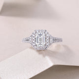 Emerald-cut halo moissanite ring with double pavé split shank and side stones