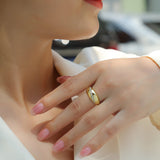 Moissanite dome band ring on hand, yellow gold vermeil with white stones and black swoosh