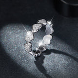 Side view: heart moissanite ring with six raised heart settings, white gold vermeil