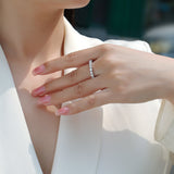 Pavé eternity ring with round moissanite stones worn on finger, white gold vermeil