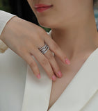 Crossover moissanite band on finger with multiple pavé rows