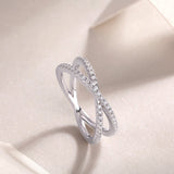 X-Cross Moissanite pavé band view from the side with stone-set crossover on white metal