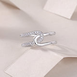 White gold tone wide band moissanite ring with oval halo detail and pavé