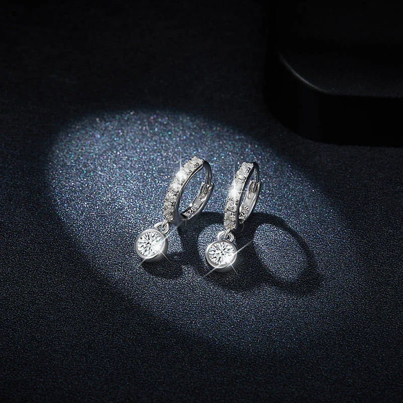 Huggie hoop earrings with pavé bezel band and round dangling moissanite