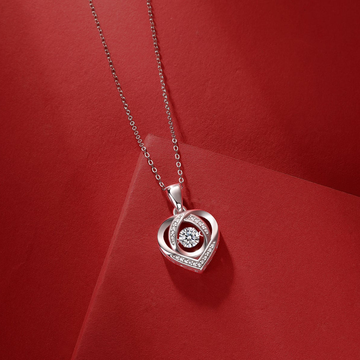 Close-up heart pendant with round moissanite center and pavé edges on chain