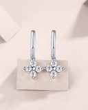 Four-petal flower moissanite drop huggie earrings with round side stones, silver-tone