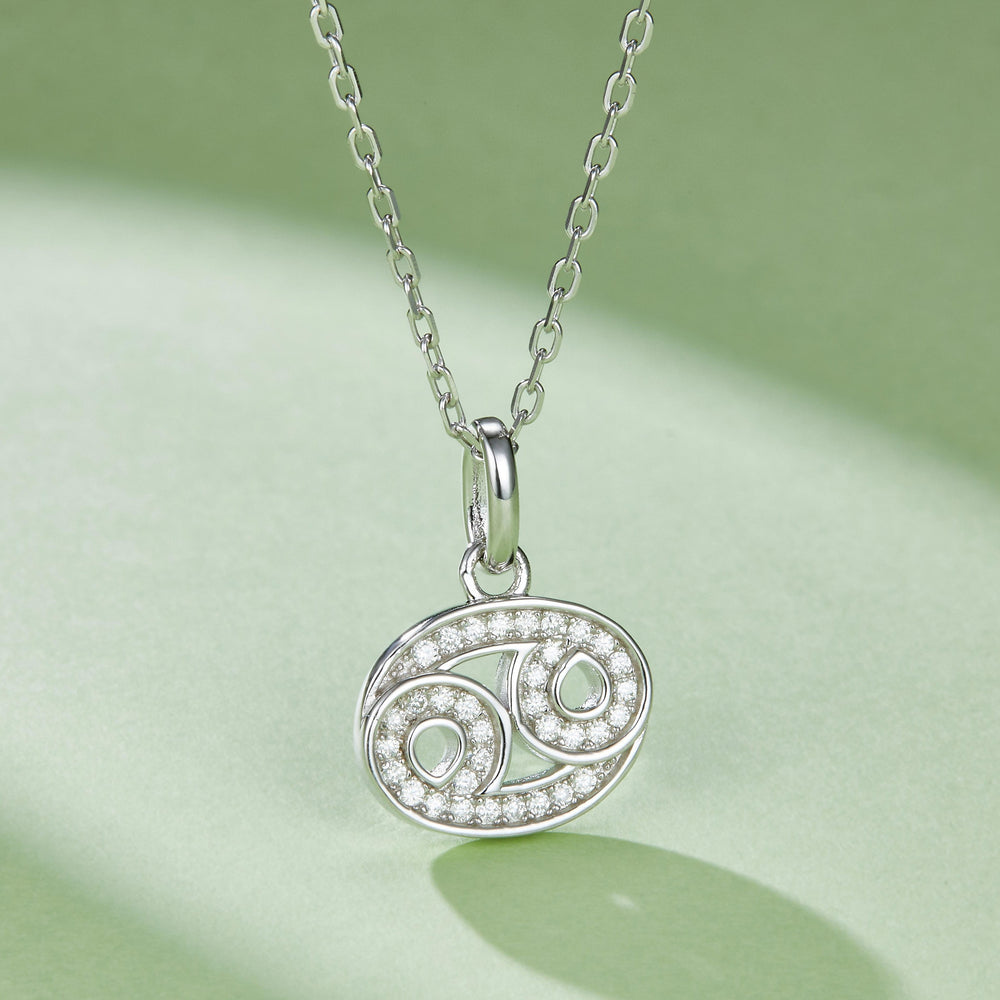 Oval Cancer pendant necklace with green accent stones and pave border on chain
