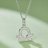 Libra zodiac pendant necklace with circular center and halo of small stones
