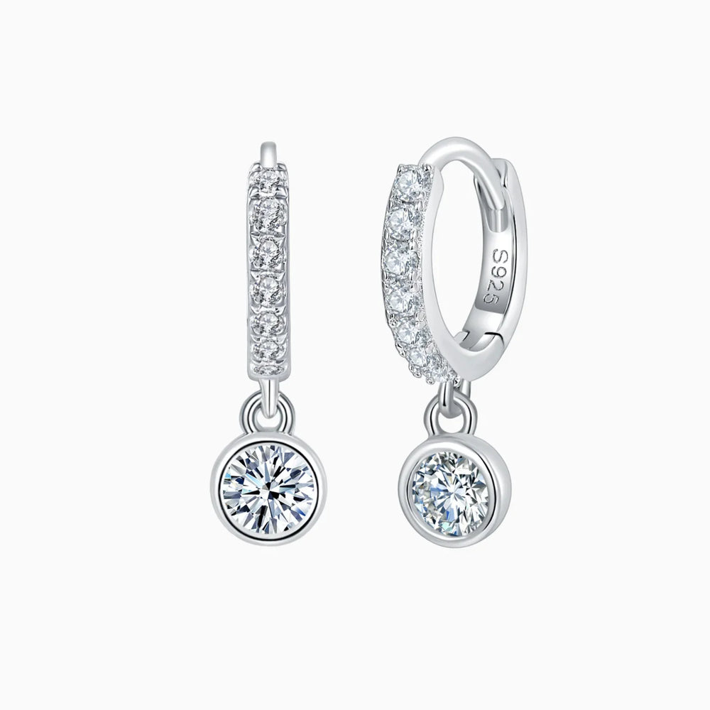 Side view of pavé huggie bezel earrings with round moissanite dangling