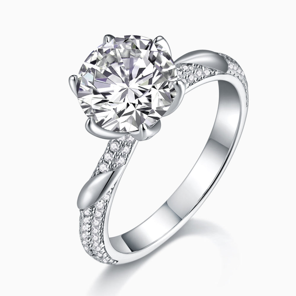 Twisted pavé moissanite ring with round center stone; split shank covered in small stones