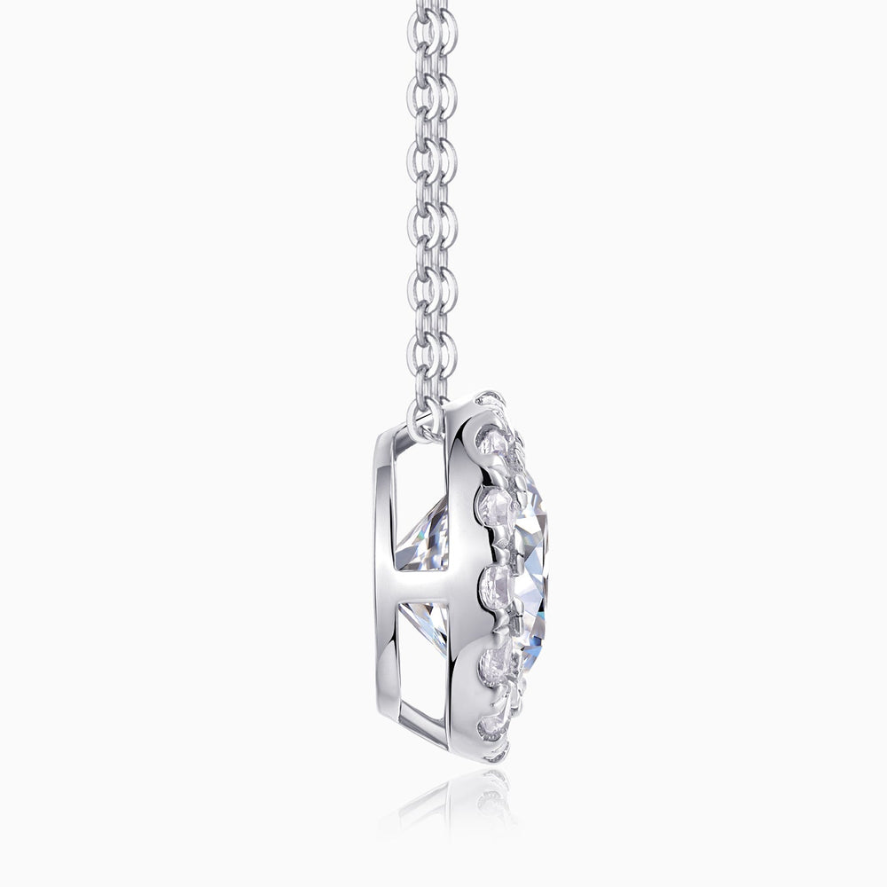 Side view of round halo moissanite pendant in silver-tone setting on link chain