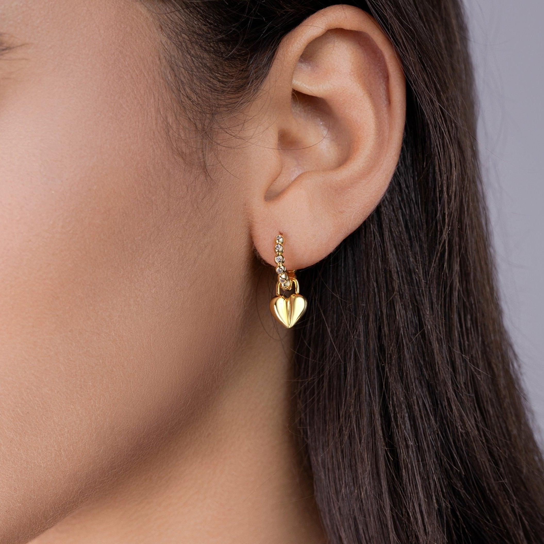 Ear view: yellow gold vermeil huggie with beaded chain and heart charm
