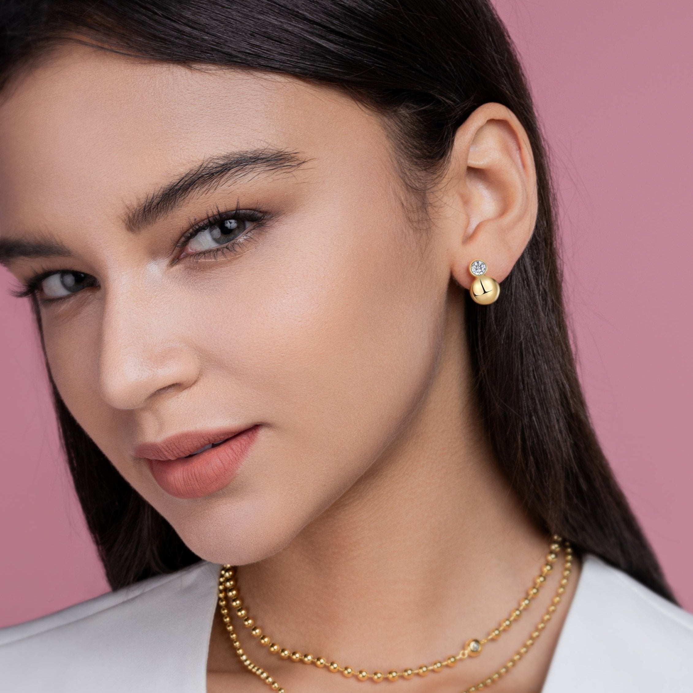 Close-up: gold vermeil bezel moissanite ball stud earrings on model ear