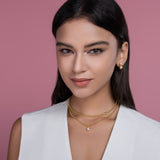 Model wearing double-layer beaded necklace set with round blue gem pendant, yellow gold