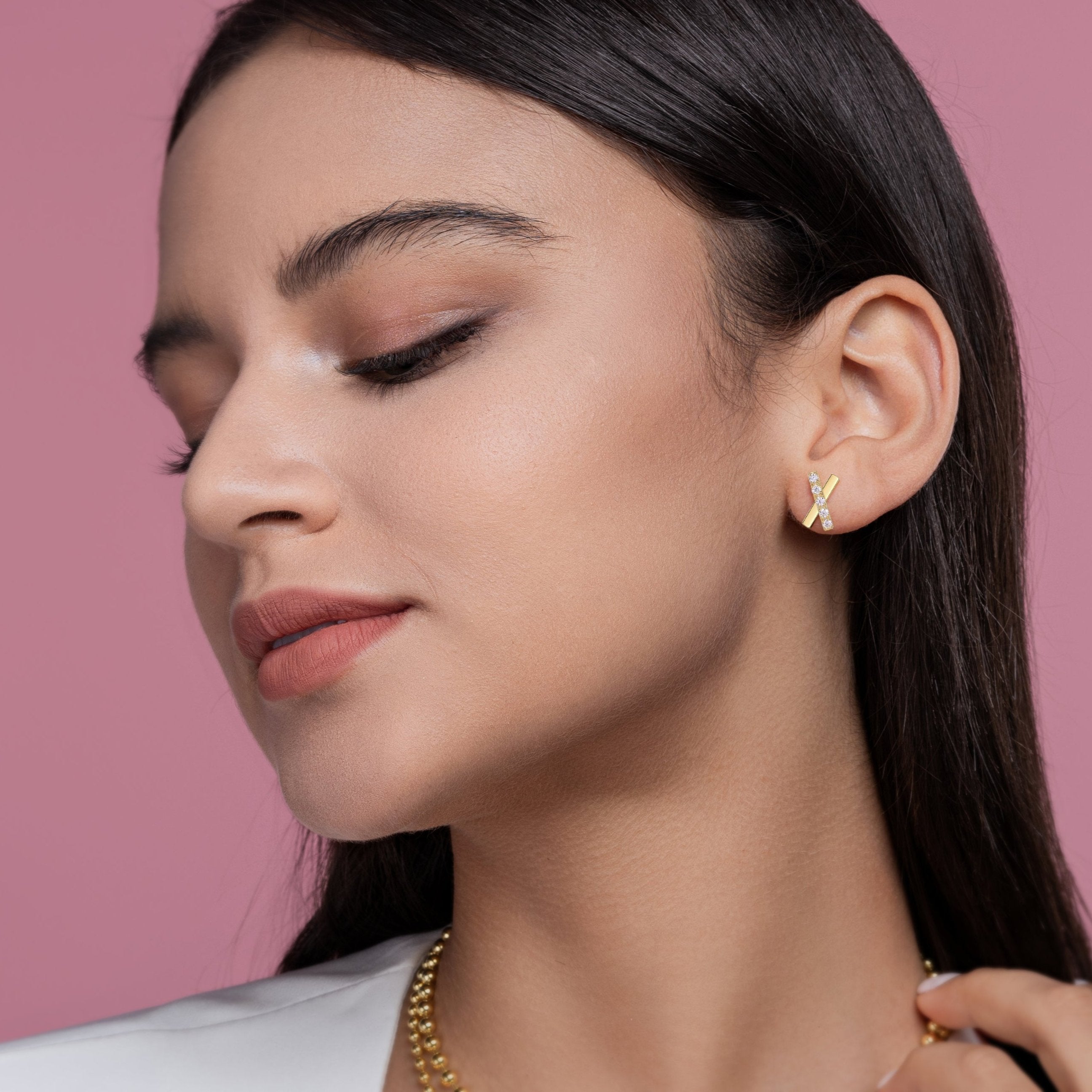 Yellow gold cross stud earrings with moissanite pave detail on ear