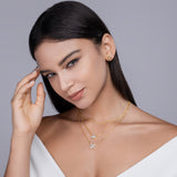 Gold-tone layered necklace on model: small stone and butterfly pendant