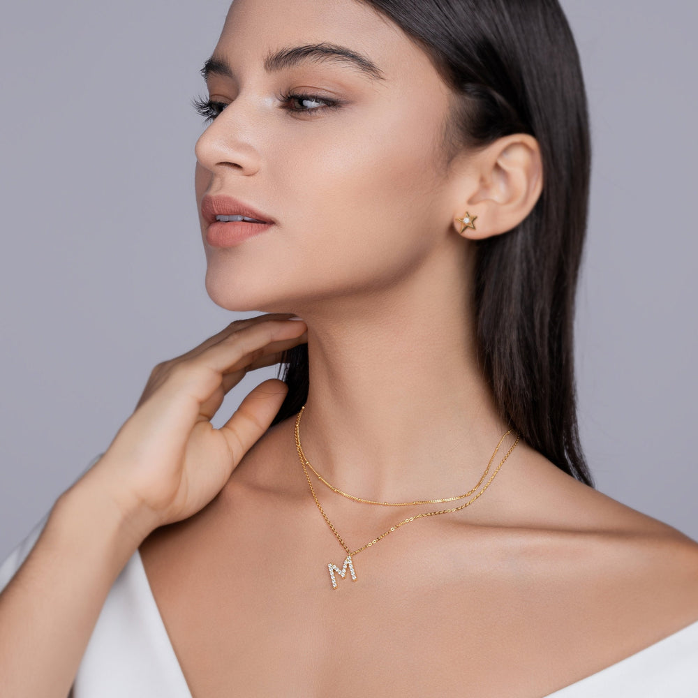 Model wearing yellow gold vermeil double-layer M necklace with moissanite stones