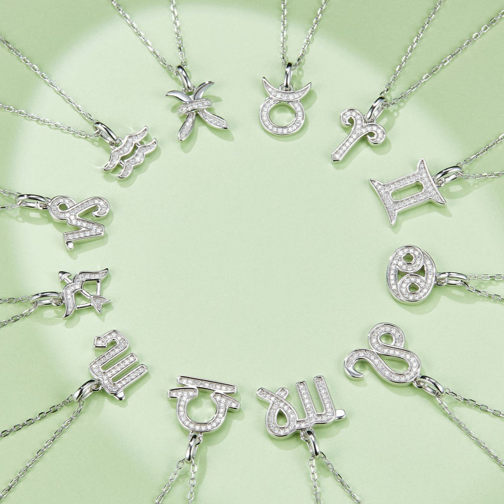 Assorted zodiac pendants on chains, including Aquarius wave charm with stones
