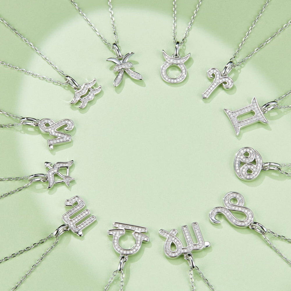 Multiple zodiac pendant necklaces with jeweled motifs on silver-toned chains