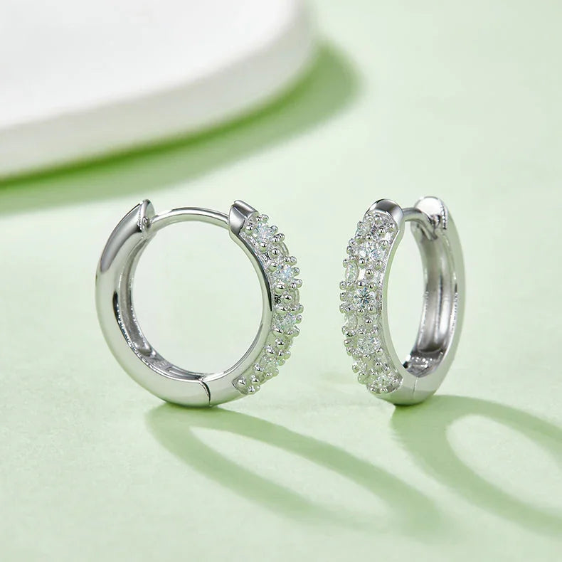 White gold vermeil half-pavé huggie hoop earrings, close view of the stone-studded half band