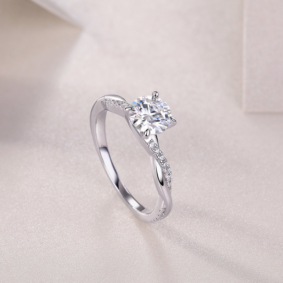 Round cut moissanite pavé ring, angled view of round center stone and pavé shank