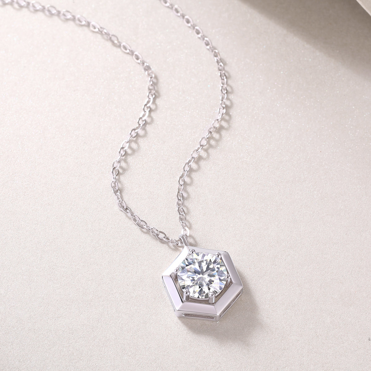 Close-up hexagon frame moissanite pendant, round brilliant stone, white gold vermeil