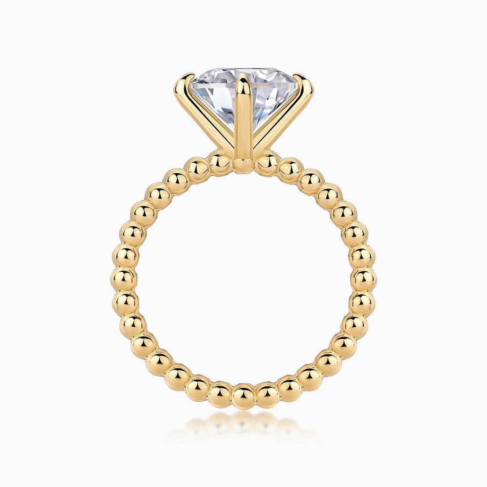Solitaire round-cut moissanite ring with yellow gold plated beaded shank and raised prongs