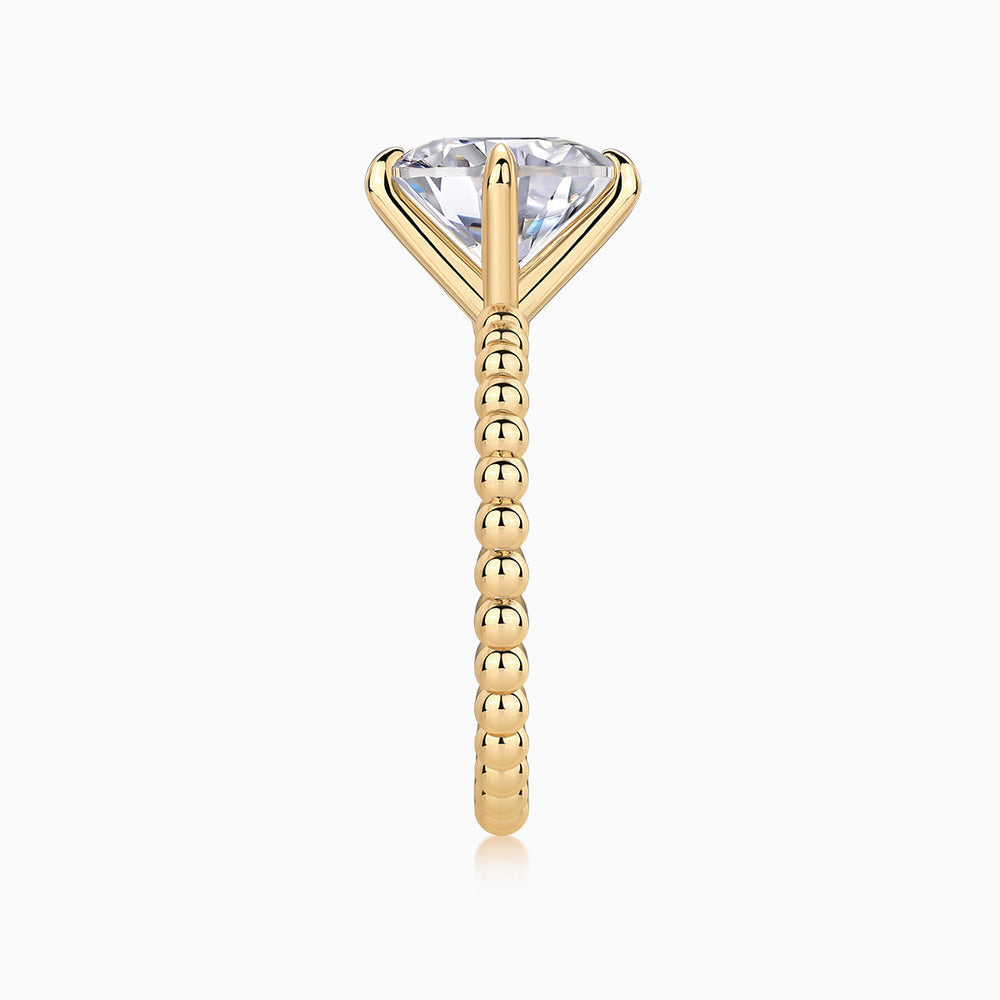 Profile of yellow gold plated solitaire ring with round moissanite center and beaded ring shank