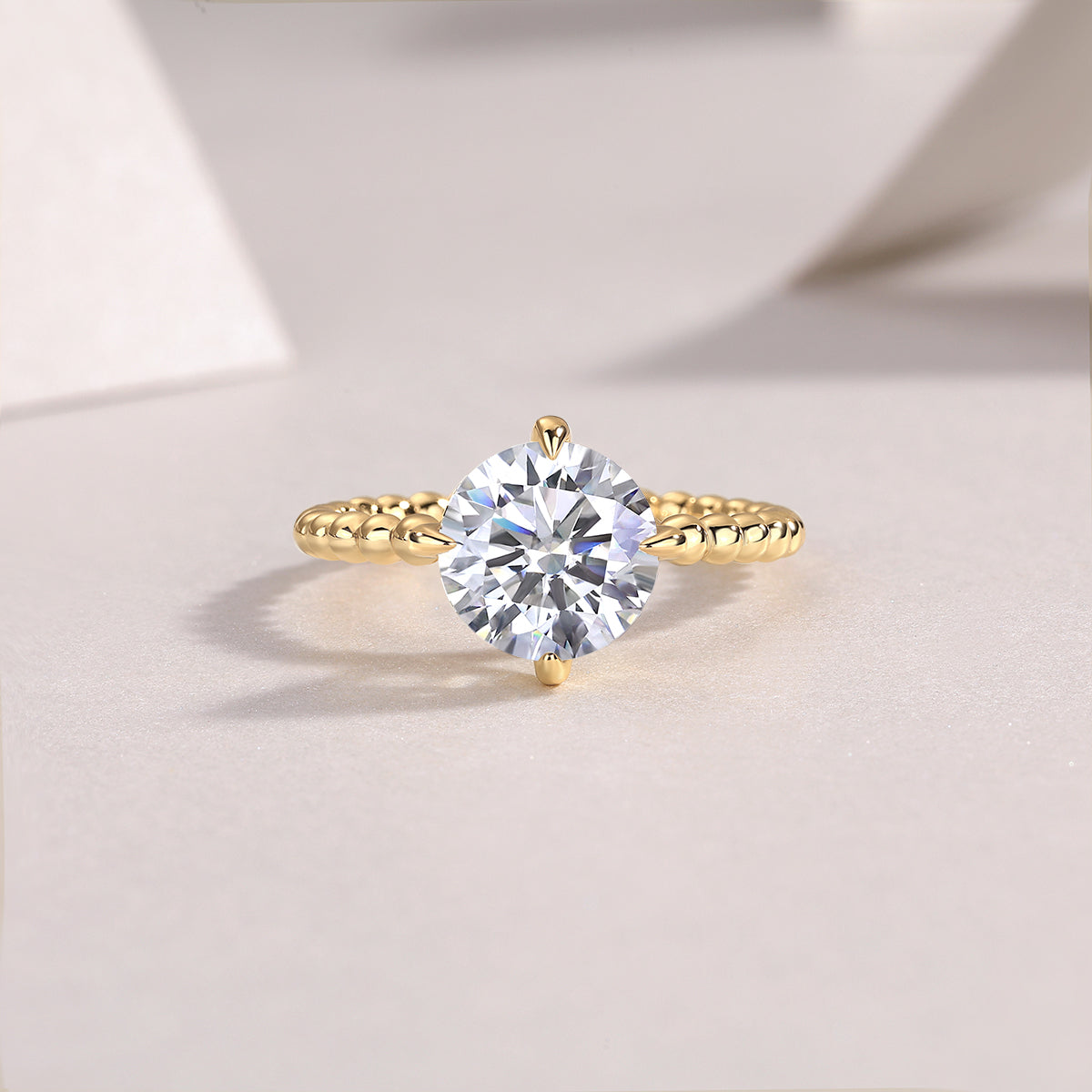 Round moissanite solitaire ring in yellow gold plated with beaded shoulders and prong setting