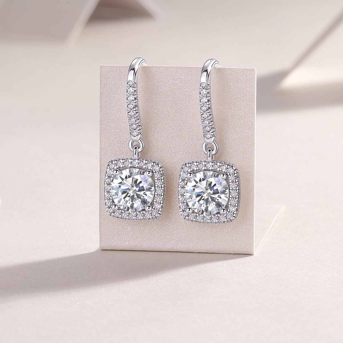 Pair of cushion halo drop earrings with prong-set center stone and pavé halo, white gold