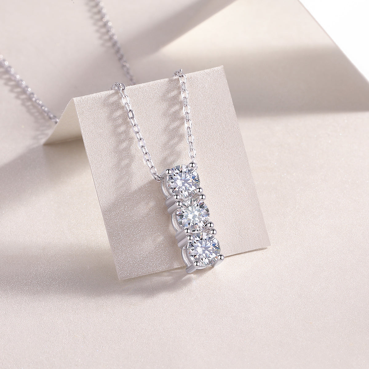 3-stone vertical bar moissanite pendant with three clear stones in silver-tone setting