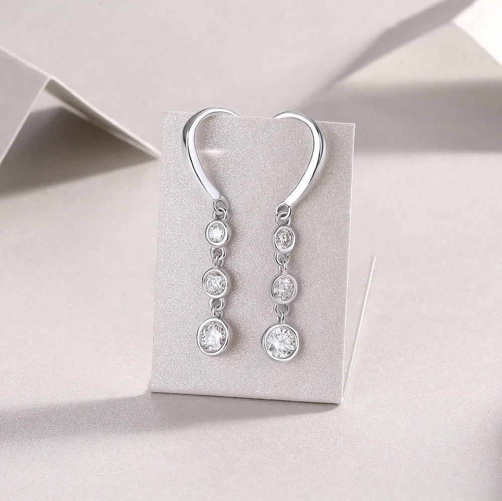 Three-stone moissanite drop earrings with round bezels and lever hook, white gold vermeil