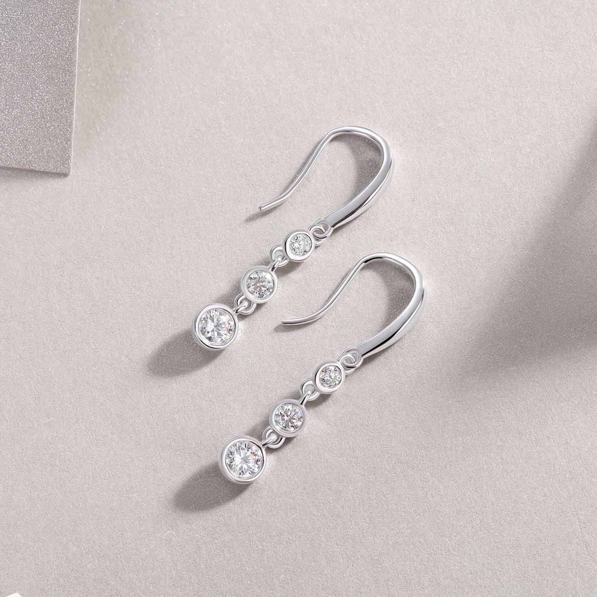 Long drop view: 3 graduated round moissanite stones on earrings, white gold vermeil