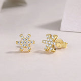 Snowflake stud earrings, yellow gold vermeil finish with white stones, front view