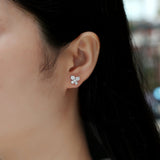 Clover moissanite stud earrings on ear, four round stones, white gold vermeil