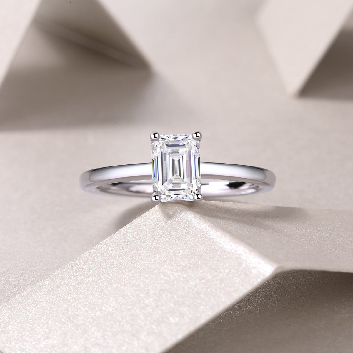 Solitaire emerald-cut moissanite ring, emerald-cut center stone in four-prong setting