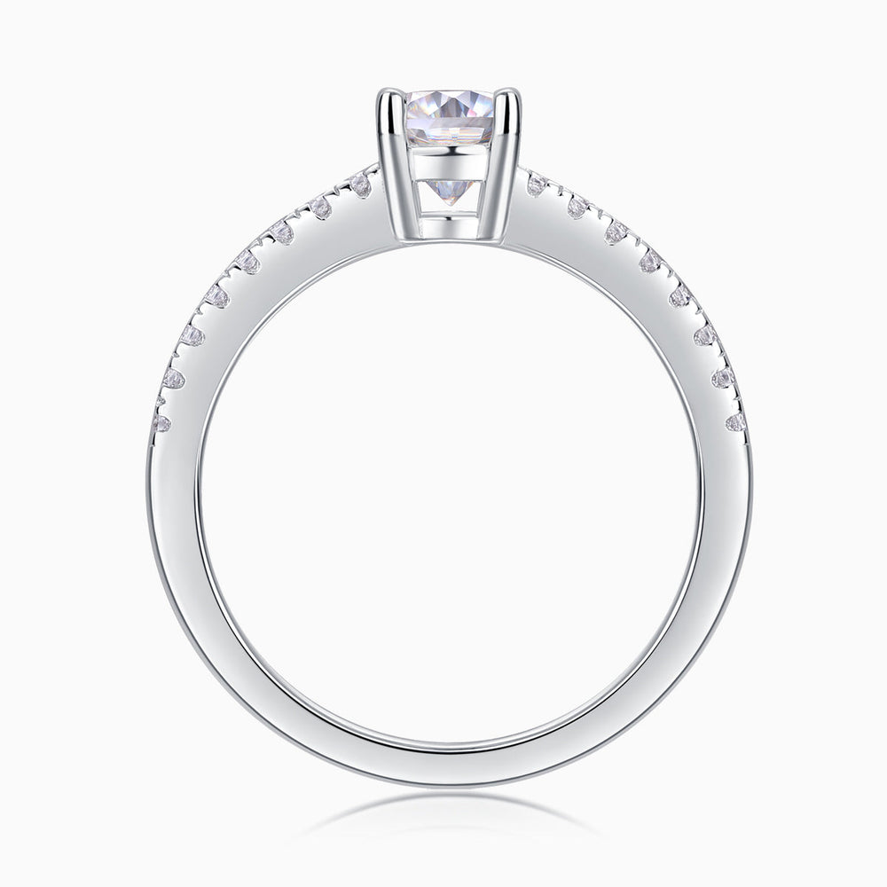 Top view of oval-cut moissanite engagement ring, pavé stones around the upper band