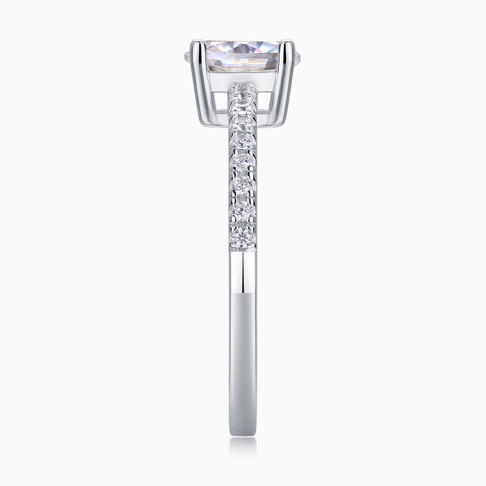 Side view of oval-cut moissanite ring with pavé band and halo-like prong basket